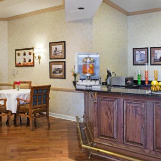 A cozy dining area with a breakfast bar featuring a coffee machine and various drink options.
