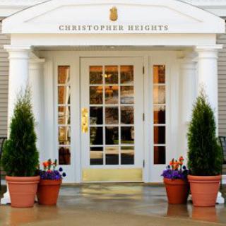 Entrance of a building with potted plants and glass door.