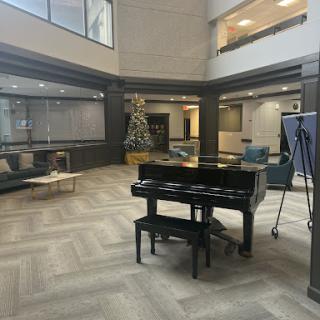 A modern lobby featuring a grand piano and comfortable seating arrangements.