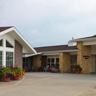 A charming entrance to a modern residential building surrounded by vibrant flowers.