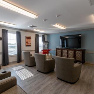 A cozy living room with comfortable seating, a large TV, and a popcorn machine.