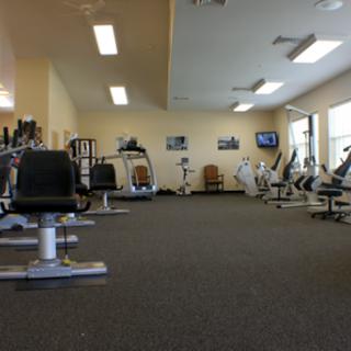 A spacious gym area equipped with various fitness machines and a clean environment.