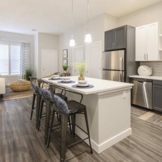 A modern kitchen with a sleek design featuring a central island and stainless steel appliances.