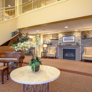 A warm and inviting lobby featuring elegant seating, a piano, and tasteful decorations.
