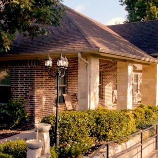 A brick house with a cozy front porch and well-maintained landscaping.