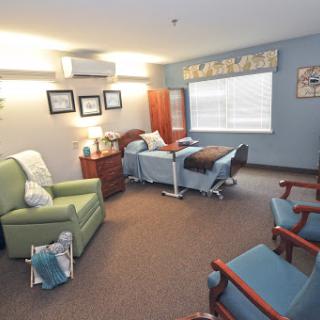 A cozy patient room in a healthcare facility, featuring comfortable seating and well-designed interiors.