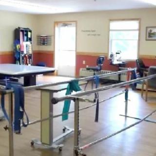 A physical therapy room equipped with parallel bars and exercise equipment.