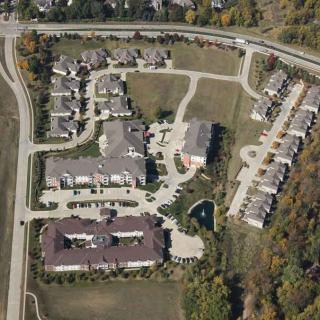 Aerial view of a residential housing complex surrounded by roads and greenery.