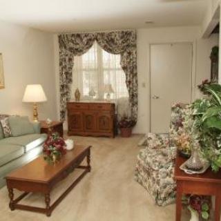 A cozy living room with floral decor and comfortable seating.