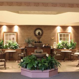A cozy indoor seating area with a central fountain surrounded by lush plants.