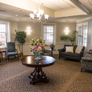 A well-decorated living room featuring elegant furniture and a central flower arrangement.