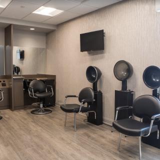 Modern salon interior with styling chairs and hair drying stations.