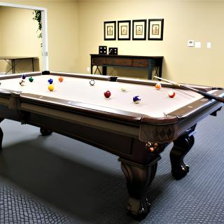 A pool table with cue stick and balls in a game room setting.