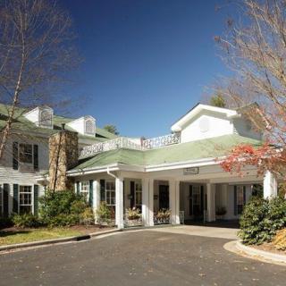 Charming residential building with a grand entrance and surrounding greenery.