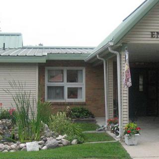 A building entrance with a neatly maintained garden at the front.
