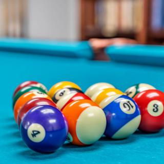 A set of billiard balls arranged on a pool table, ready for a game.