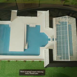 Aerial view of a detailed architectural model featuring a building with a swimming pool and solar panels.