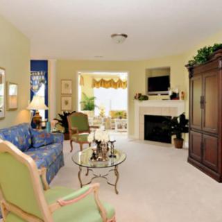 A cozy living room with a sofa, armchairs, and a fireplace.
