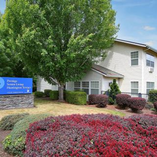 An apartment complex with well-maintained landscaping and a prominent sign in front.
