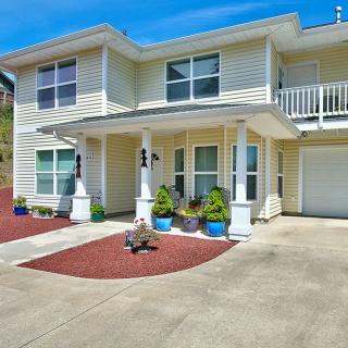 A two-story residential house with a porch, balcony, and driveway.