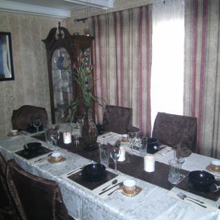 A formal dining room setup with a neatly arranged table and decorative elements.