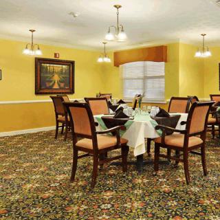 A well-decorated dining room featuring elegant furniture and warm lighting.