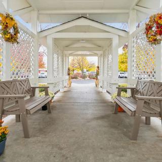 A beautifully decorated gazebo featuring benches and autumn wreaths.