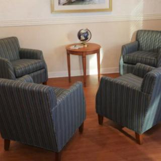 A cozy seating arrangement with four striped armchairs around a small wooden table.