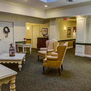 A cozy interior space with comfortable chairs and tables arranged in a warmly lit room.