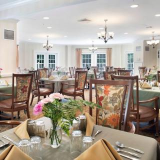 An elegantly set dining room with floral arrangements and classic decor.