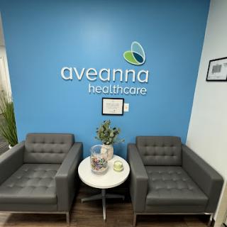 A stylish waiting area at Aveanna Healthcare, featuring comfortable seating and a calming blue wall.