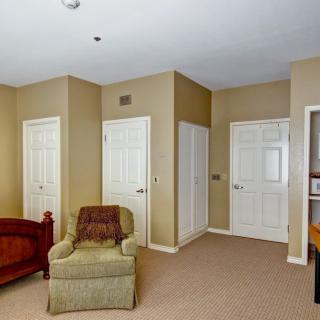 A cozy living room with a comfortable chair and multiple doors.