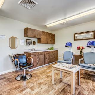A well-lit salon interior with seating, hair dryers, and a neat waiting area.