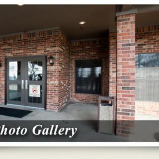 Entrance of a brick building with glass doors and a porch.
