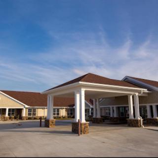 A welcoming entrance to a residential building under a clear blue sky.