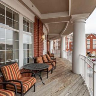 A spacious balcony with comfortable seating and elegant architectural columns.