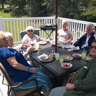 A cheerful gathering of friends enjoying lunch together on a sunny patio.