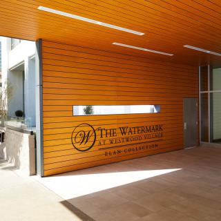 Modern entrance with wooden paneling and signage.
