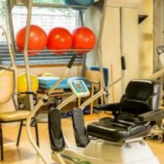 A well-equipped gym room with various exercise machines and fitness balls.