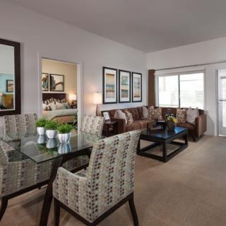 A stylish and modern living room with a dining space, featuring elegant furniture and decor.