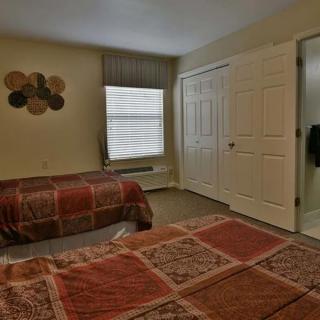 A cozy bedroom with two beds and warm decor.