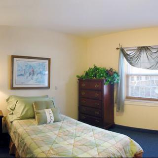 A cozy bedroom with a single bed, window, and dresser.