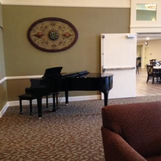 A cozy living room featuring a grand piano and stylish decor.