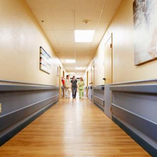 A view down a hospital corridor with staff in the distance.