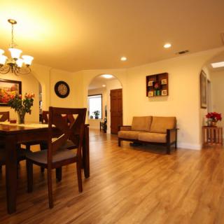 A cozy dining and living area with elegant wood flooring and warm lighting.