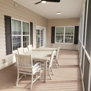 A cozy screened patio featuring a dining table and chairs, perfect for outdoor gatherings.