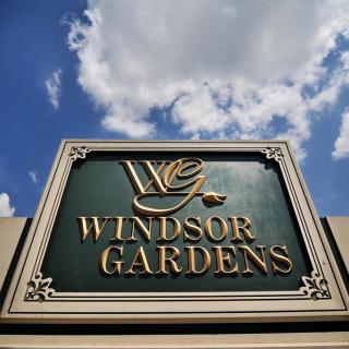 A sign for Windsor Gardens against a backdrop of clouds and blue sky.