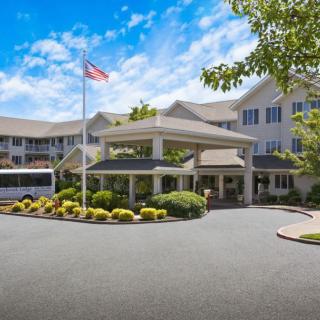 A hotel entrance with a circular driveway and neatly maintained landscaping.