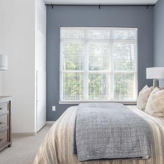 A modern, minimalist bedroom featuring natural light and neutral-toned decor.