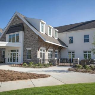 A modern residential building with a gabled roof and well-maintained lawn.